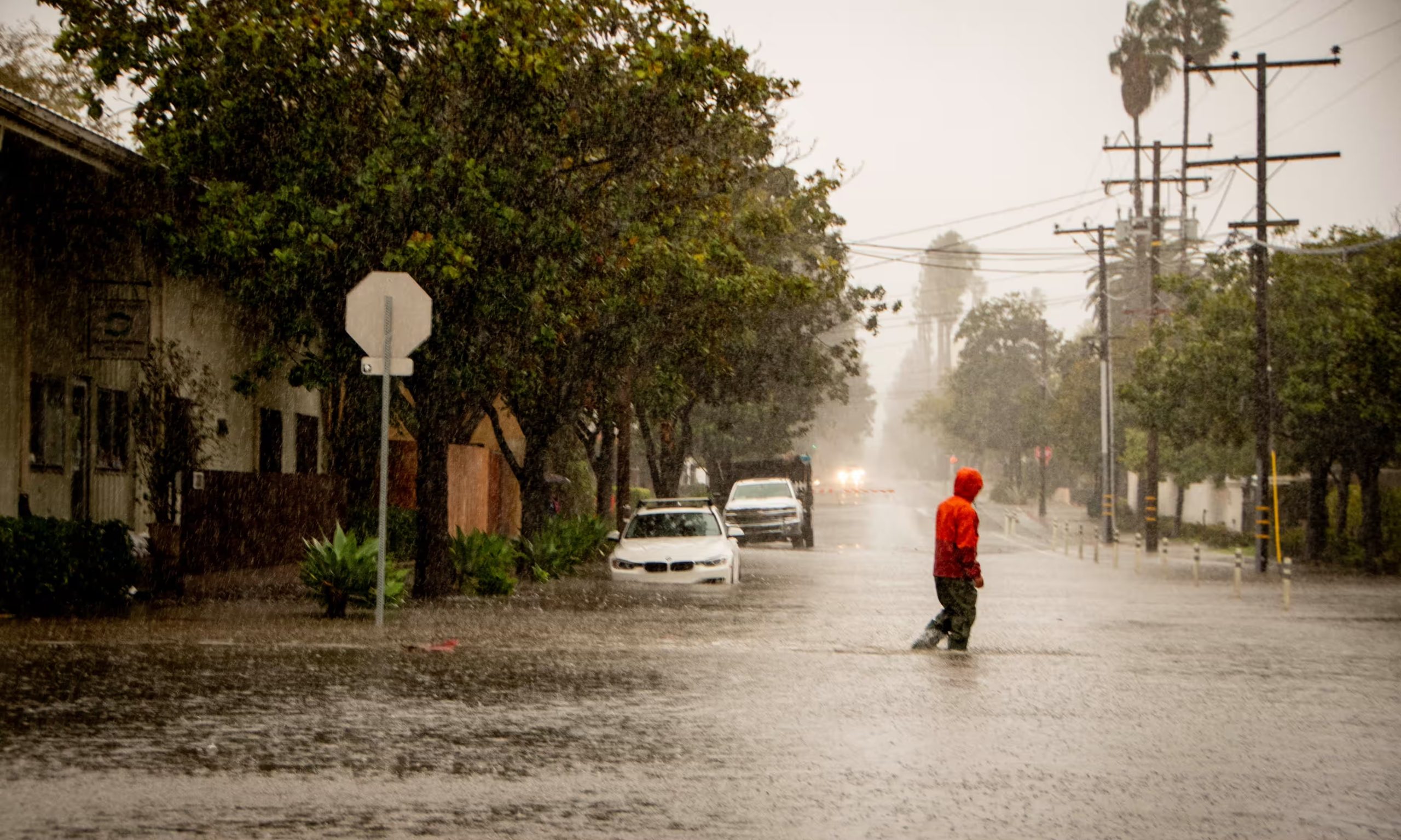 Ein Mann überquert eine überflutete Straße in Santa Barbara, Kalifornien, am 4. Februar 2024. Foto: Erick Madrid-EPA
